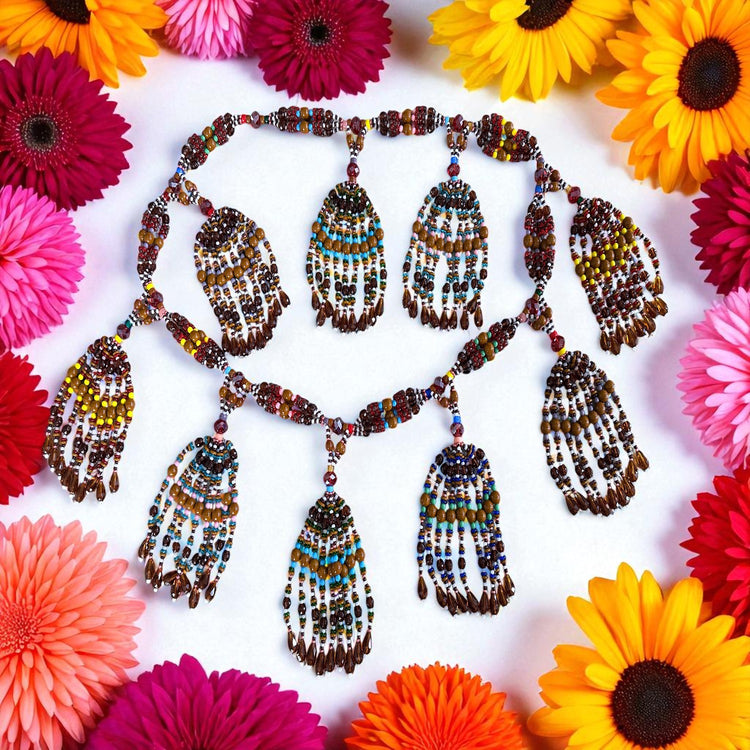 Beaded necklace with colorful pendants on a white background with flowers