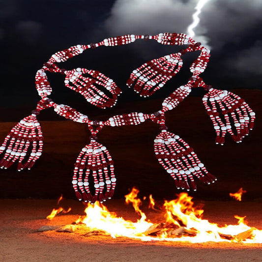 A red and white beaded necklace displayed against a fiery background, resembling the appearance of Orisha Shángo.