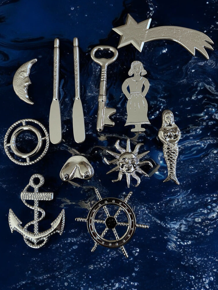 Collection of silver-colored metal tools for Yembo against a blue textured background