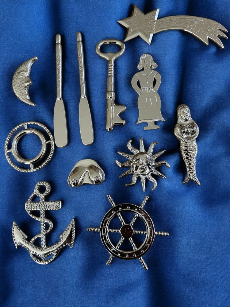 Collection of silver-colored metal tools for Yembo on a blue fabric background