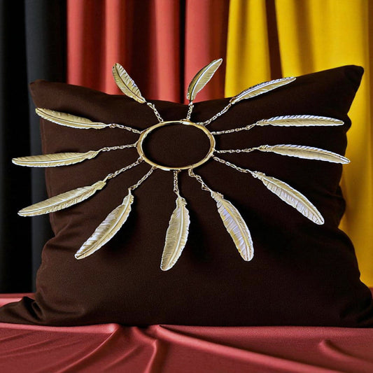 Brass Ring with 12 brass feathers on a brown velvet pillow and a draped background
