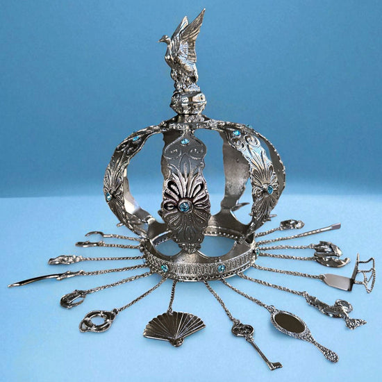 Decorative silver crown with tools and a duck topper on a blue background