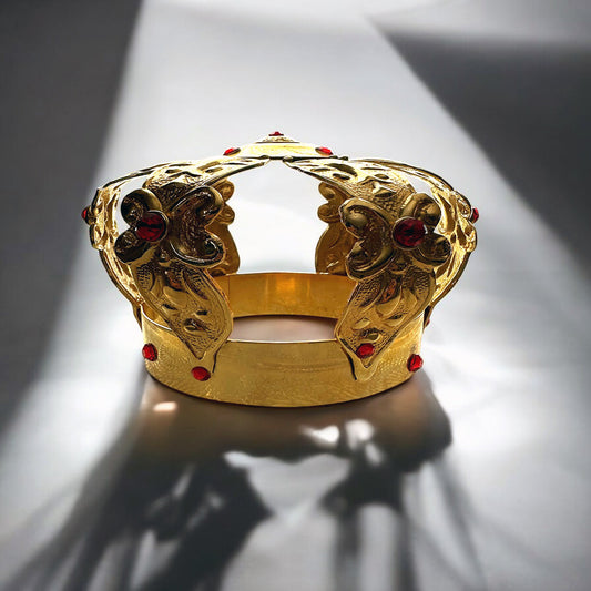 Gold-colored metal crown with ruby accents, designed for the Orisha Eleguá, depicting a stylized face with floral patterns and red eyes.