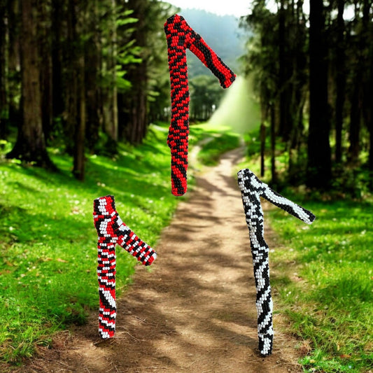 Three beaded grappling sets, each with a different color scheme, standing upright on a forest path background.