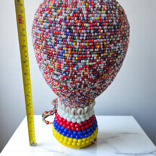 Colorful beaded gourd  on a white surface.