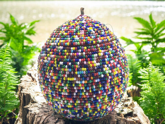 A handcrafted beaded gourd adorned with multi-colored high-quality glass beads, intended as a spiritual vessel for the Osain deity