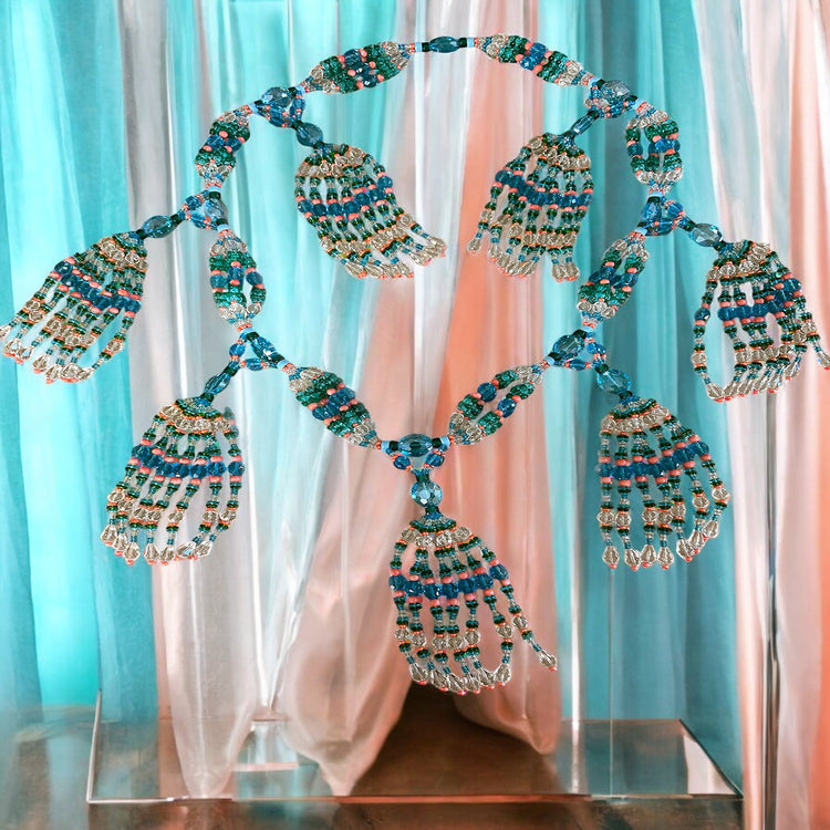 Decorative necklace with beads and tassels against a colorful curtain background