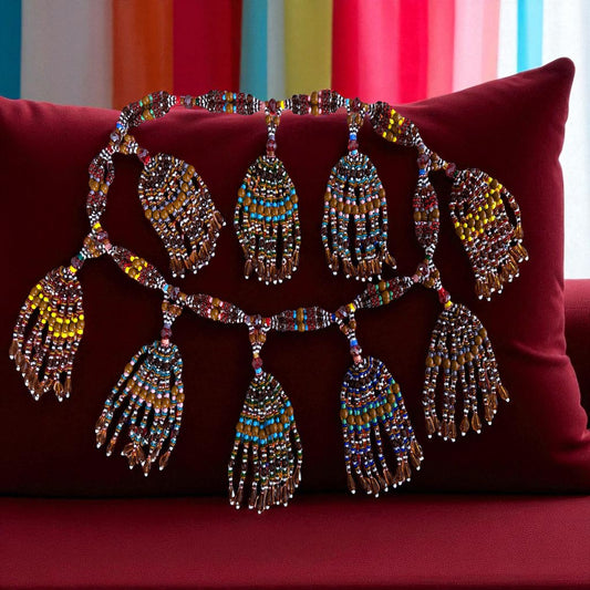 Decorative beaded necklace on a red pillow with colorful striped background