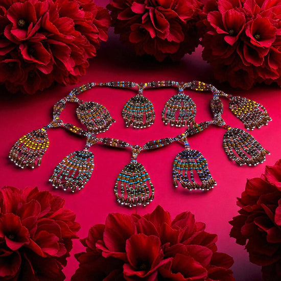 Multicolored beaded necklace on a pink background with red flowers