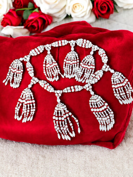 A petite 4-string mazo necklace for Obatala (Ayaguna) with red, white, and frosted Czech glass beads, displayed on a red fabric surface.