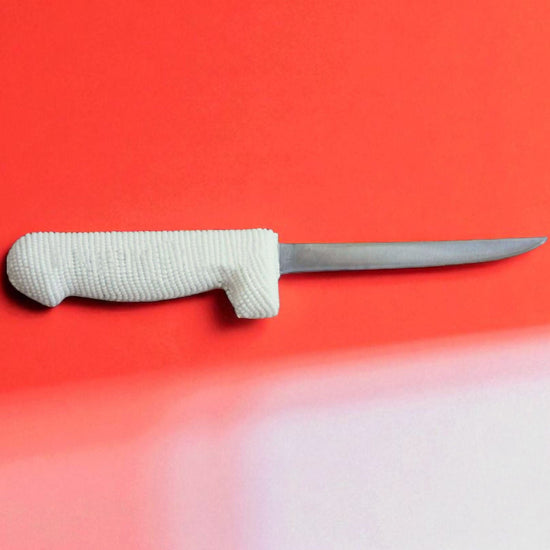 Knife with a white handle on a red background
