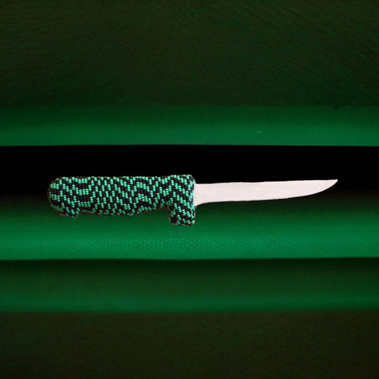Knife with a green and black patterned handle on a green background