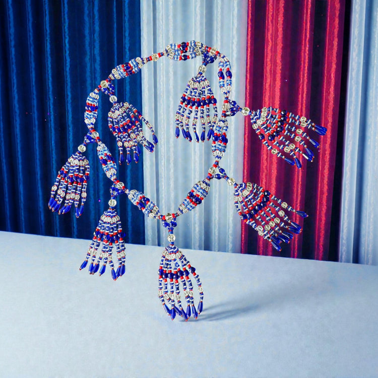 Decorative Necklace with blue, red, and silver tassels against a colorful curtain background