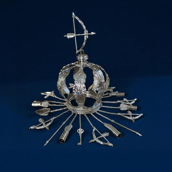 Decorative silver crown with archery elements on a dark blue background