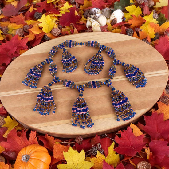Beaded necklace  on a wooden plate with autumn leaves.