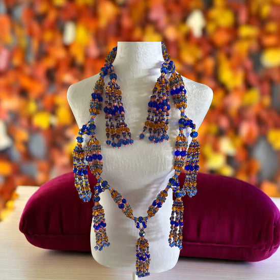 Beaded necklace on a mannequin with a colorful background.