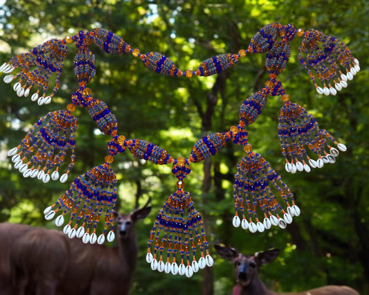 A colorful beaded mazo with multiple strands featuring sapphire blue, topaz, and pink coral acrylic beads, with a natural background.