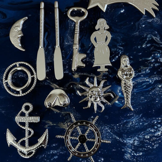 Collection of silver-colored metal tools for Yembo against a blue textured background