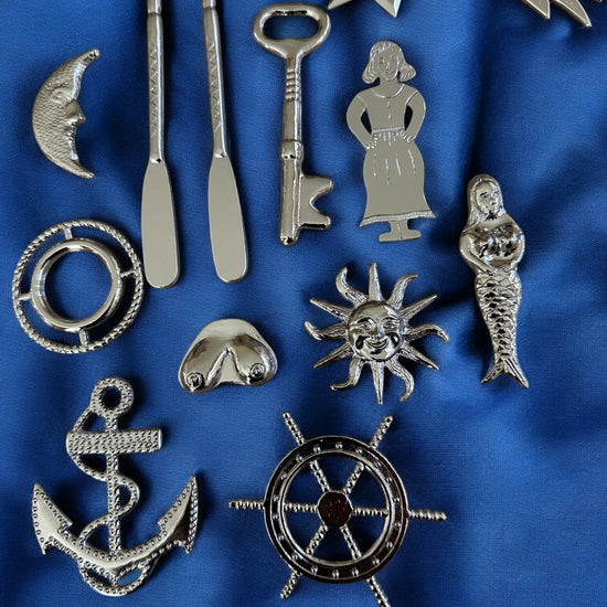 Collection of silver-colored metal tools for Yembo  on a blue fabric background