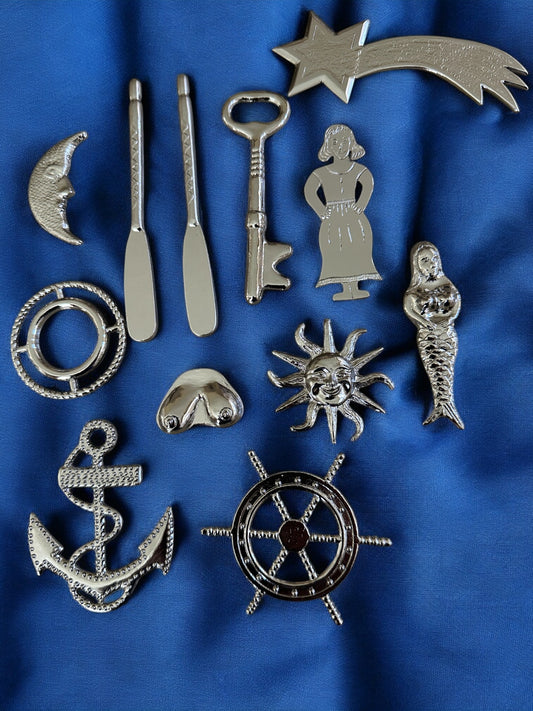 Collection of silver-colored metal tools for Yembo  on a blue fabric background